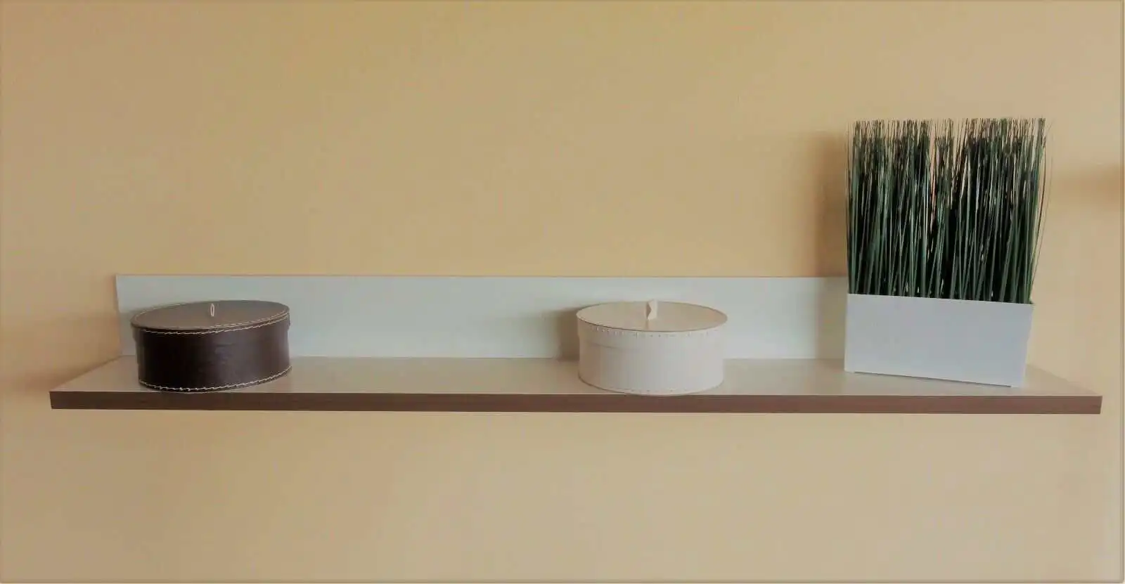 Die dezent creme-weiß, seidenmatt lackierte Ablage mit Nußbaumkante versprüht einen warmen Charme.